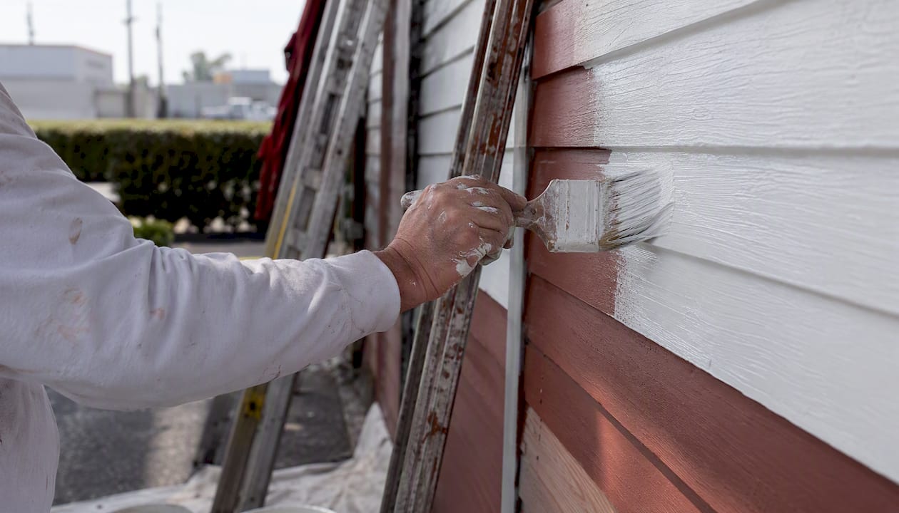 Contractor sanding commercial siding
