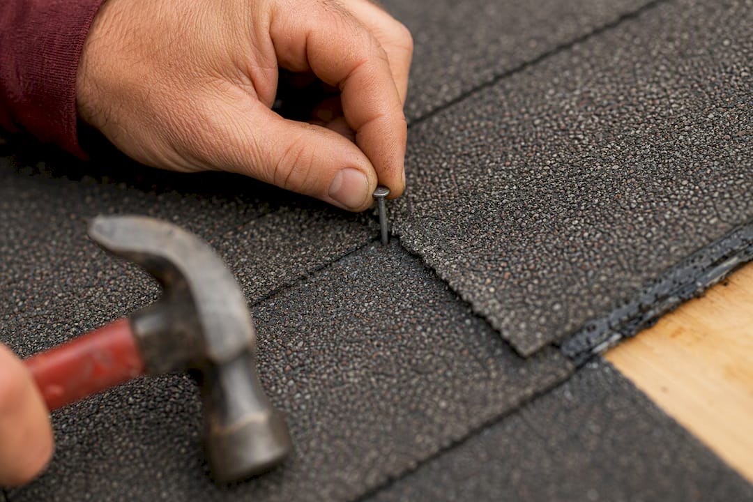 Close-up of nail placement and cement seal on asphalt shingle