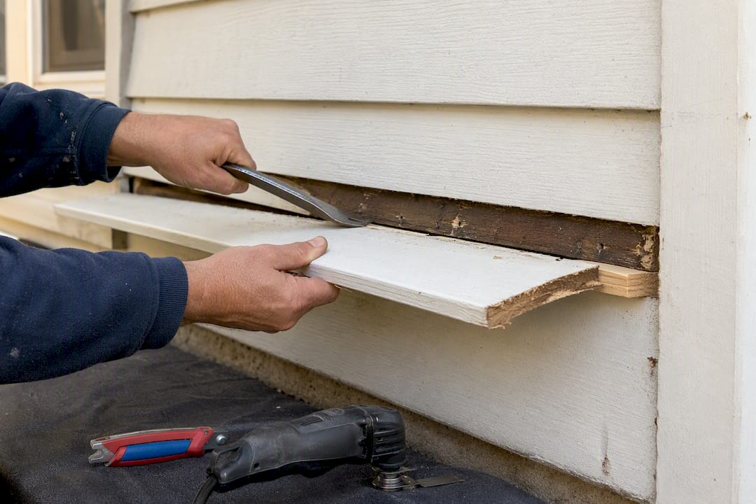 Removing a damaged wood siding board